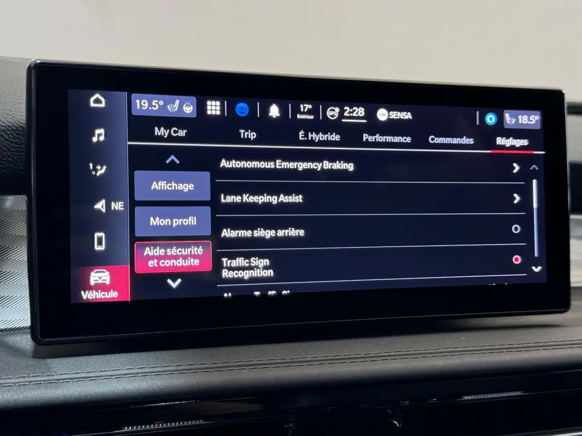 Écran tactile central affichant les réglages d'aide à la conduite de l'Alfa Romeo Tonale hybride rouge, vue intérieure frontale.