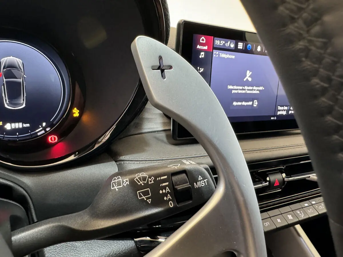 Gros plan sur la palette de changement de vitesse côté droit et l'écran tactile du tableau de bord de l'Alfa Romeo Tonale rouge.