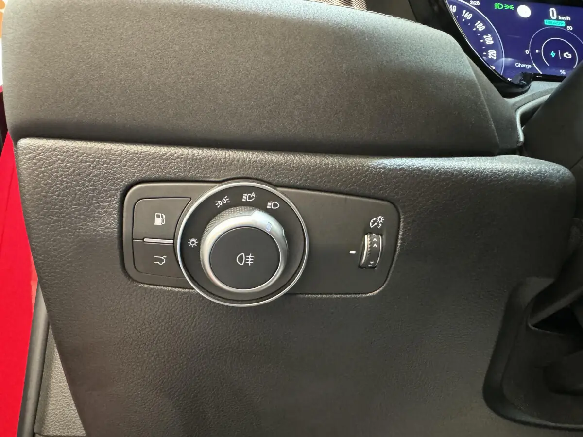 Gros plan sur la commande des feux et éclairage intérieur côté gauche d'un Alfa Romeo Tonale rouge 2023.