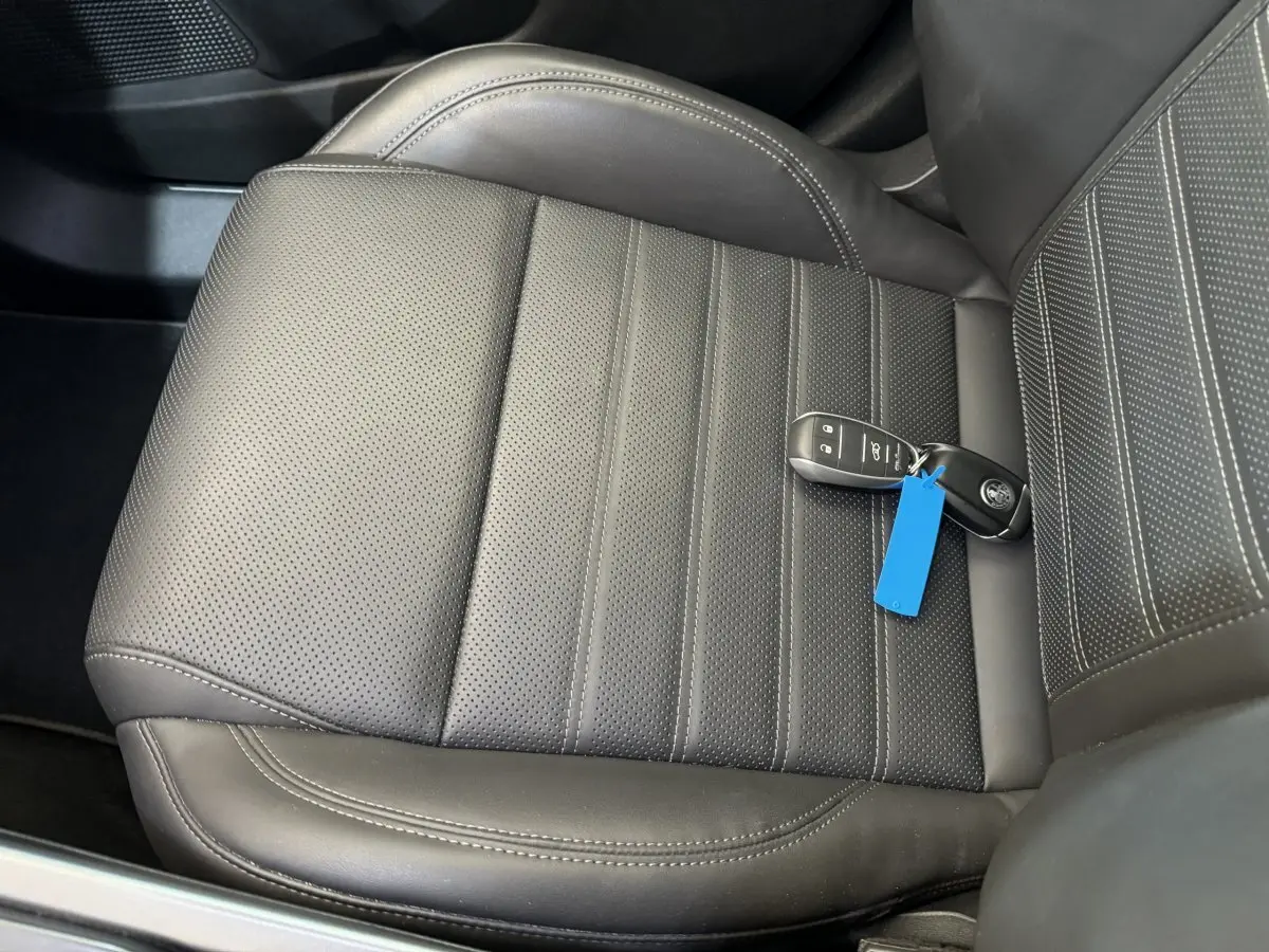 Gros plan sur le siège avant en cuir noir perforé avec la clé de l'Alfa Romeo Tonale posée dessus.