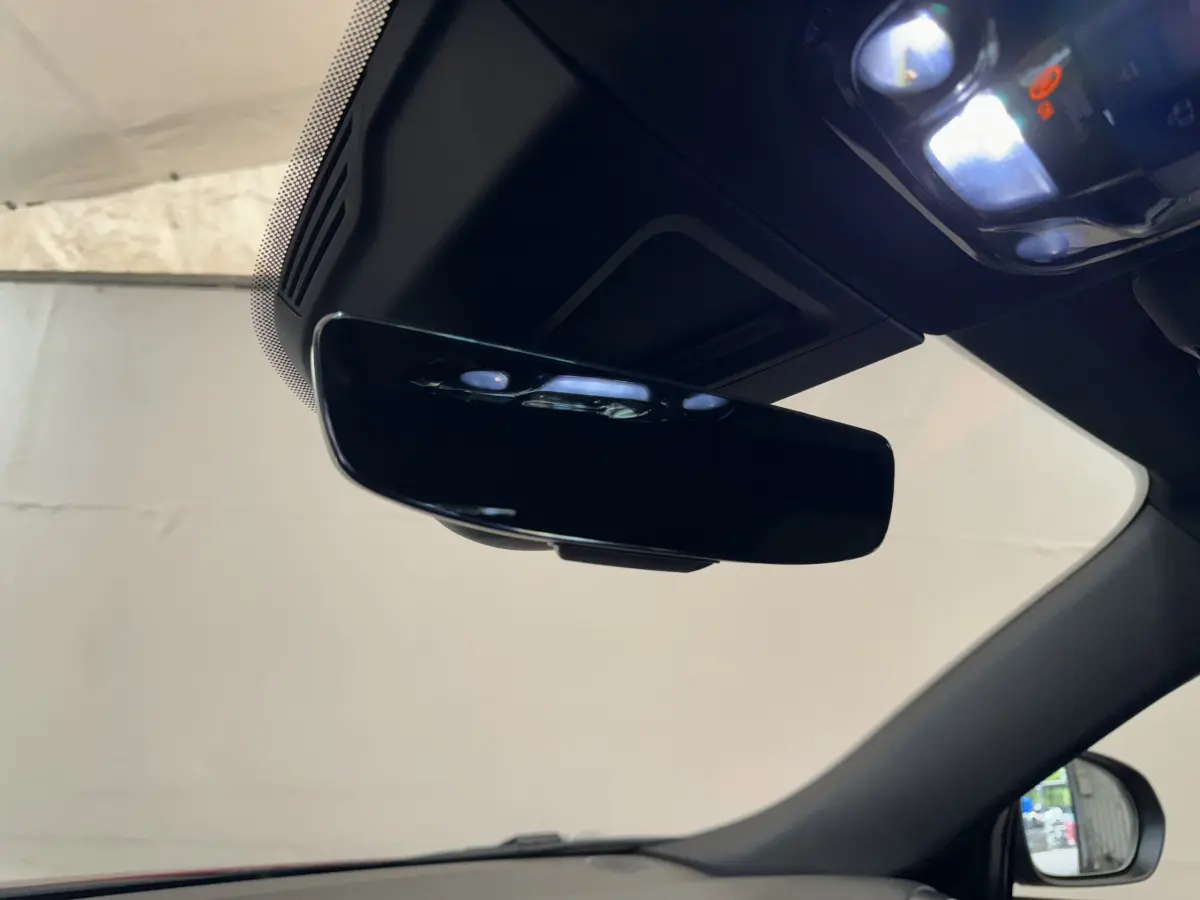 Vue intérieure rapprochée du rétroviseur central noir brillant de l'Alfa Romeo Tonale 2023, avec partie du pare-brise visible.