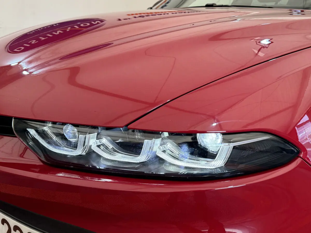 Gros plan sur le phare avant droit LED d'une Alfa Romeo Tonale rouge 2023, soulignant ses lignes modernes et précises.