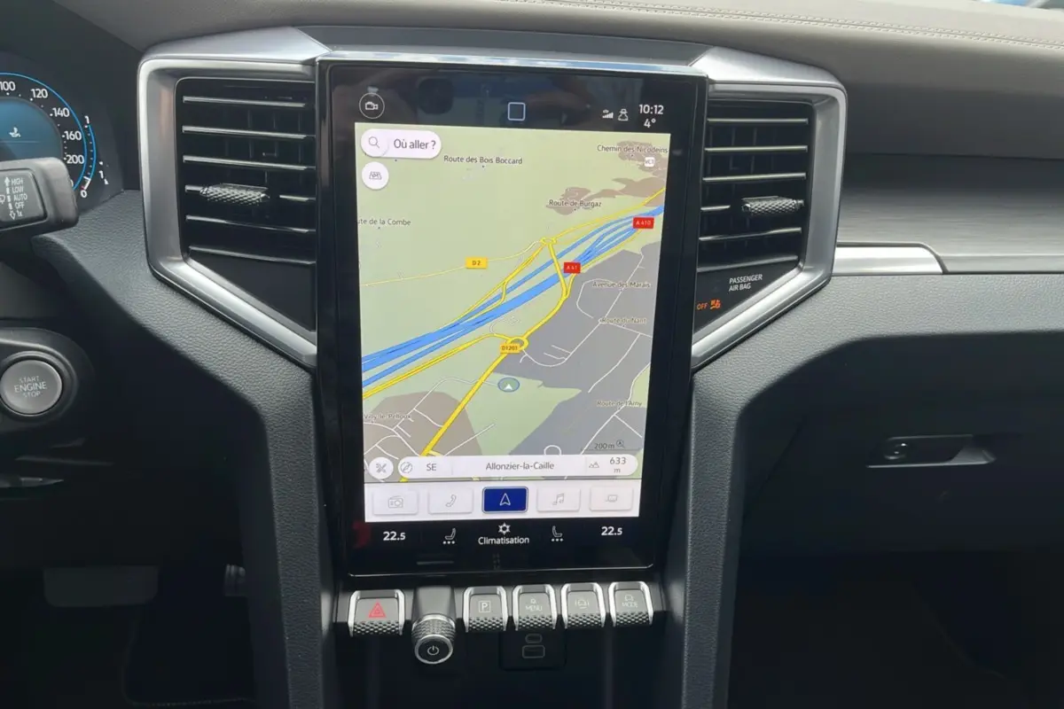 Vue rapprochée du tableau de bord noir du Volkswagen Amarok 2025 avec écran tactile central affichant la navigation.