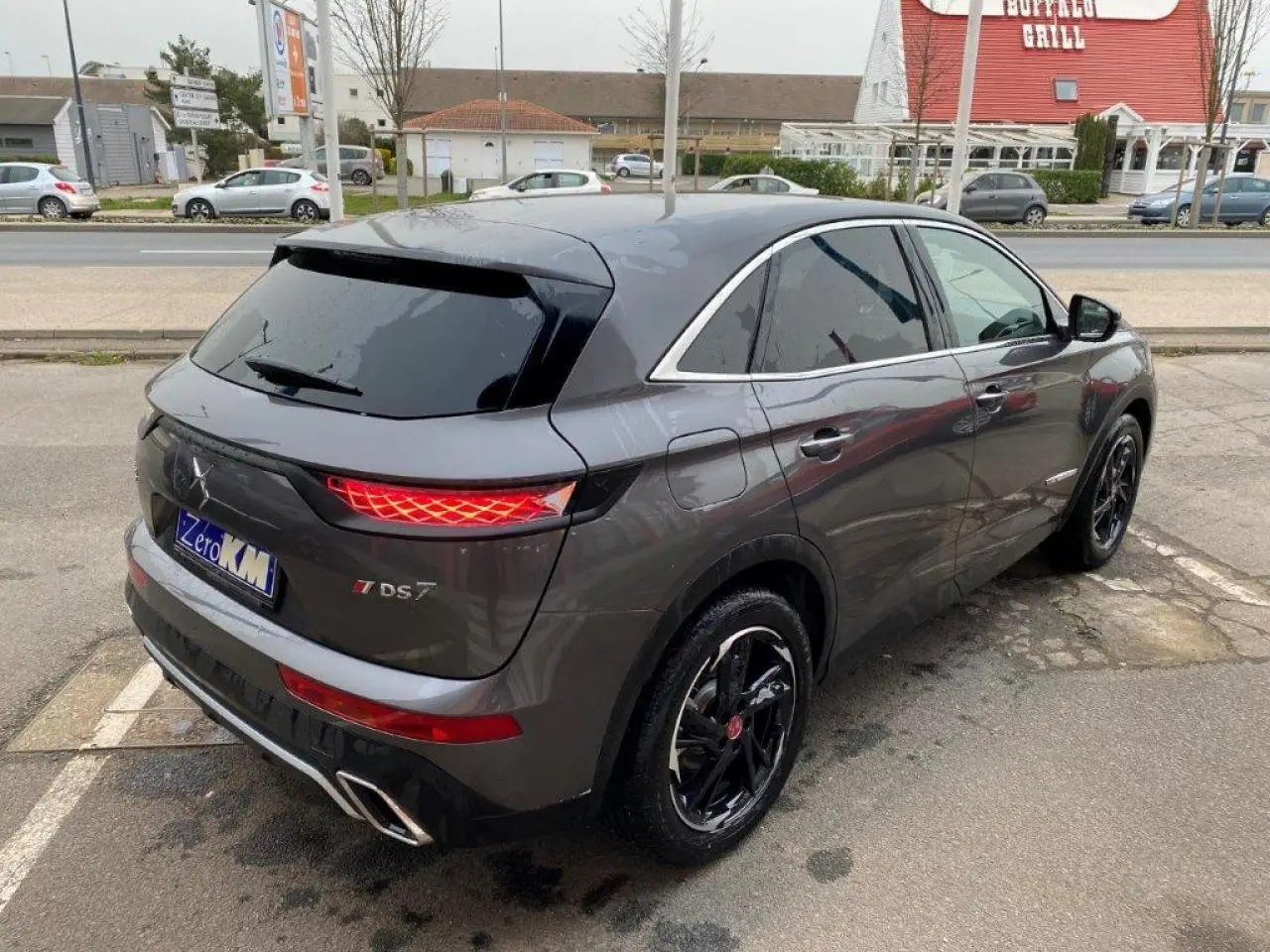 Vue 3/4 arrière droite du DS7 Crossback E-Tense gris platinium avec feux arrière LED et jantes noires brillantes.