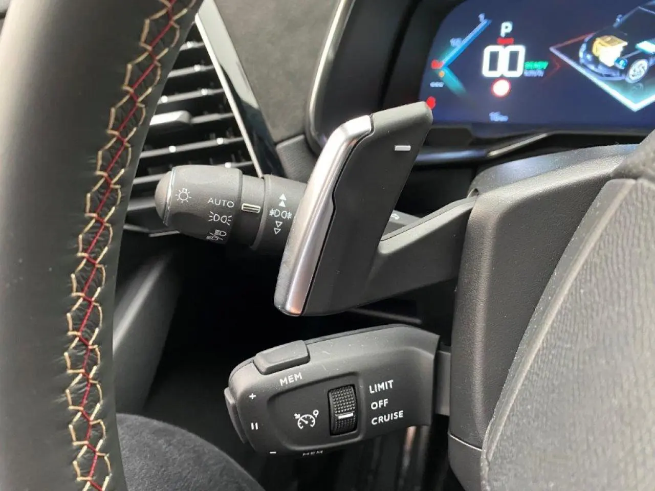 Gros plan sur les commandes au volant du DS7 Crossback E-Tense 300 gris platinium, affichage numérique en arrière-plan.