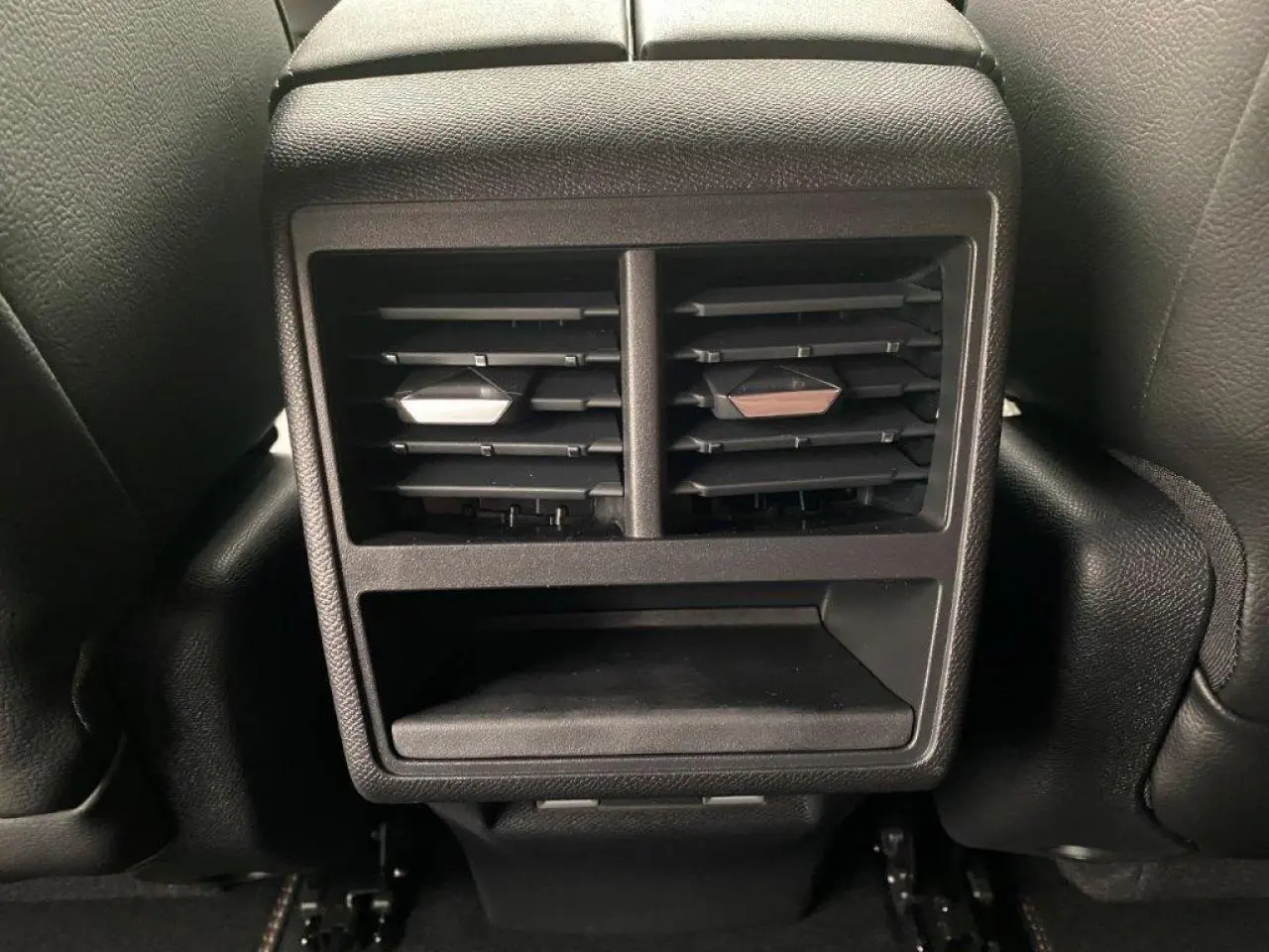 Grille d'aération arrière noire du DS7 Crossback E-Tense 2021, avec rangement intégré sous les buses.