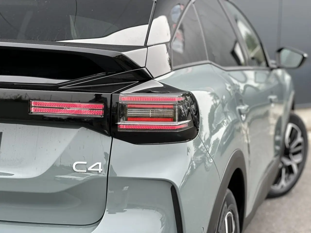 Vue arrière côté droit d'une Citroën C4 2025 Manhattan Green avec toit noir et feux arrière LED distinctifs.