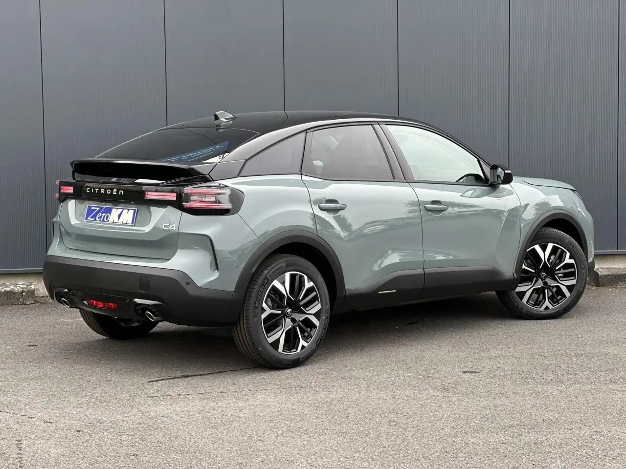 Vue 3/4 arrière droite d'une Citroën C4 Manhattan Green avec toit noir et jantes alliage 18 pouces.