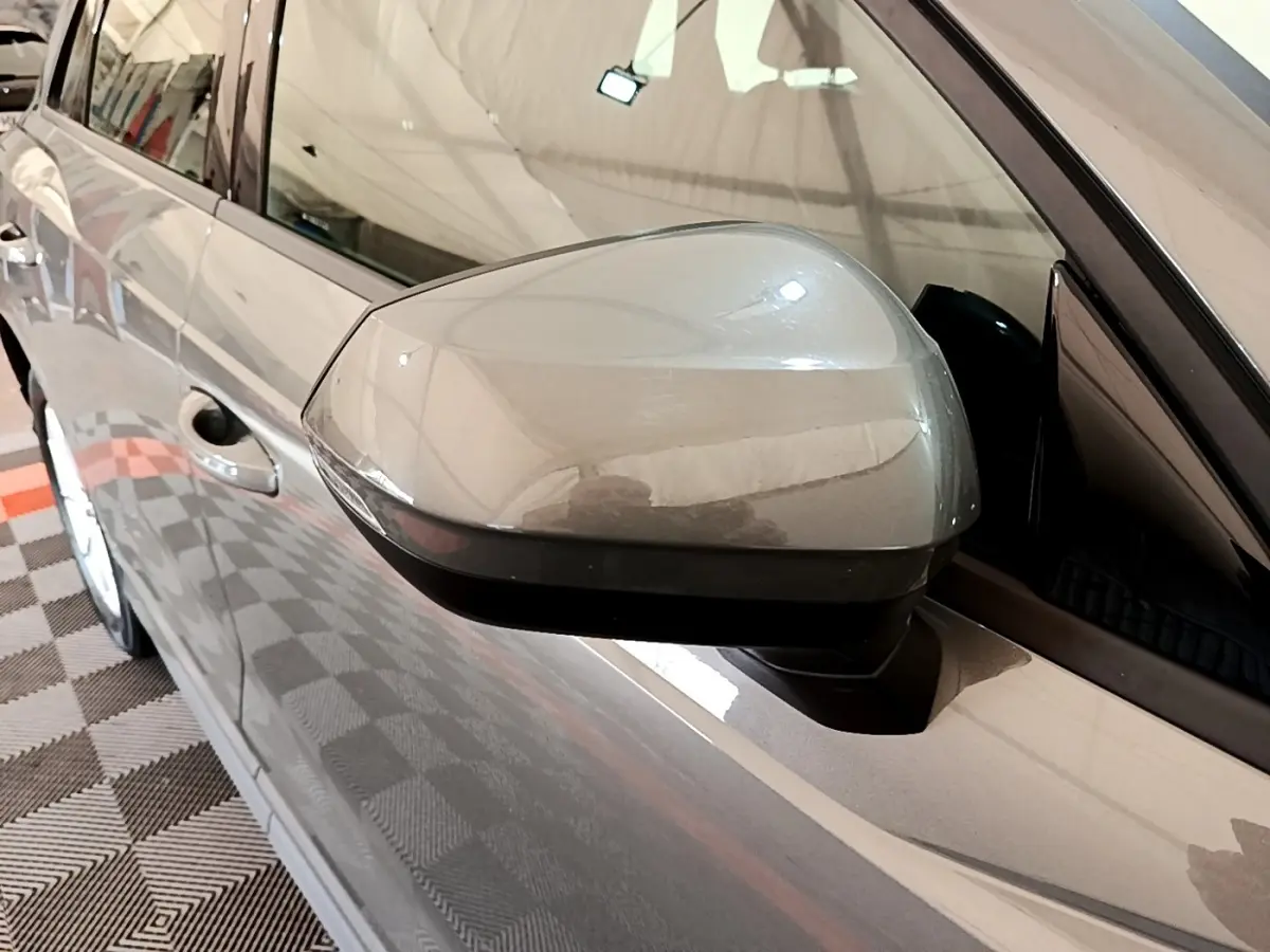 Rétroviseur côté gauche gris foncé de l'Audi Q3 35 TFSI 2021, vue rapprochée sur la portière et la vitre.