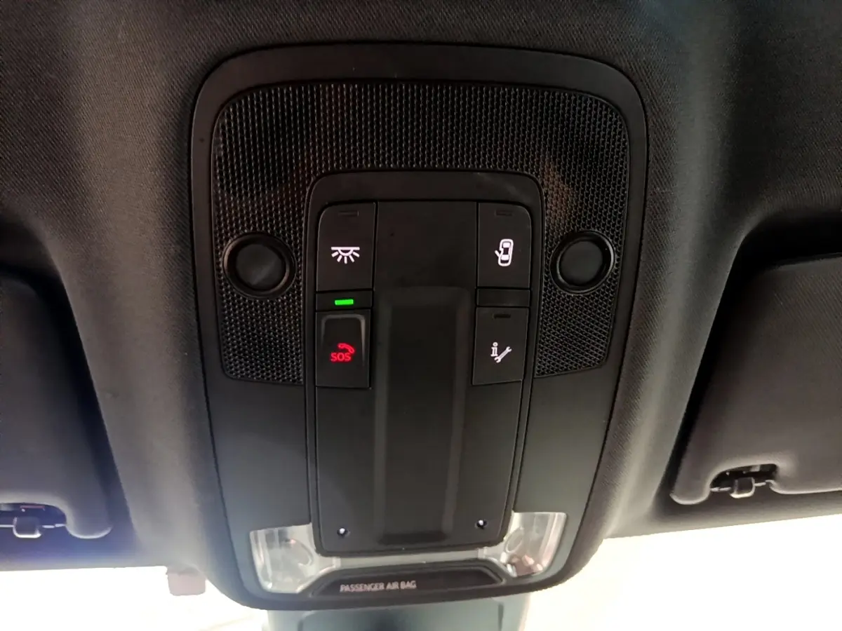 Vue en plongée du panneau de commandes au plafond de l'Audi Q3 gris foncé avec bouton SOS et éclairage intégré.