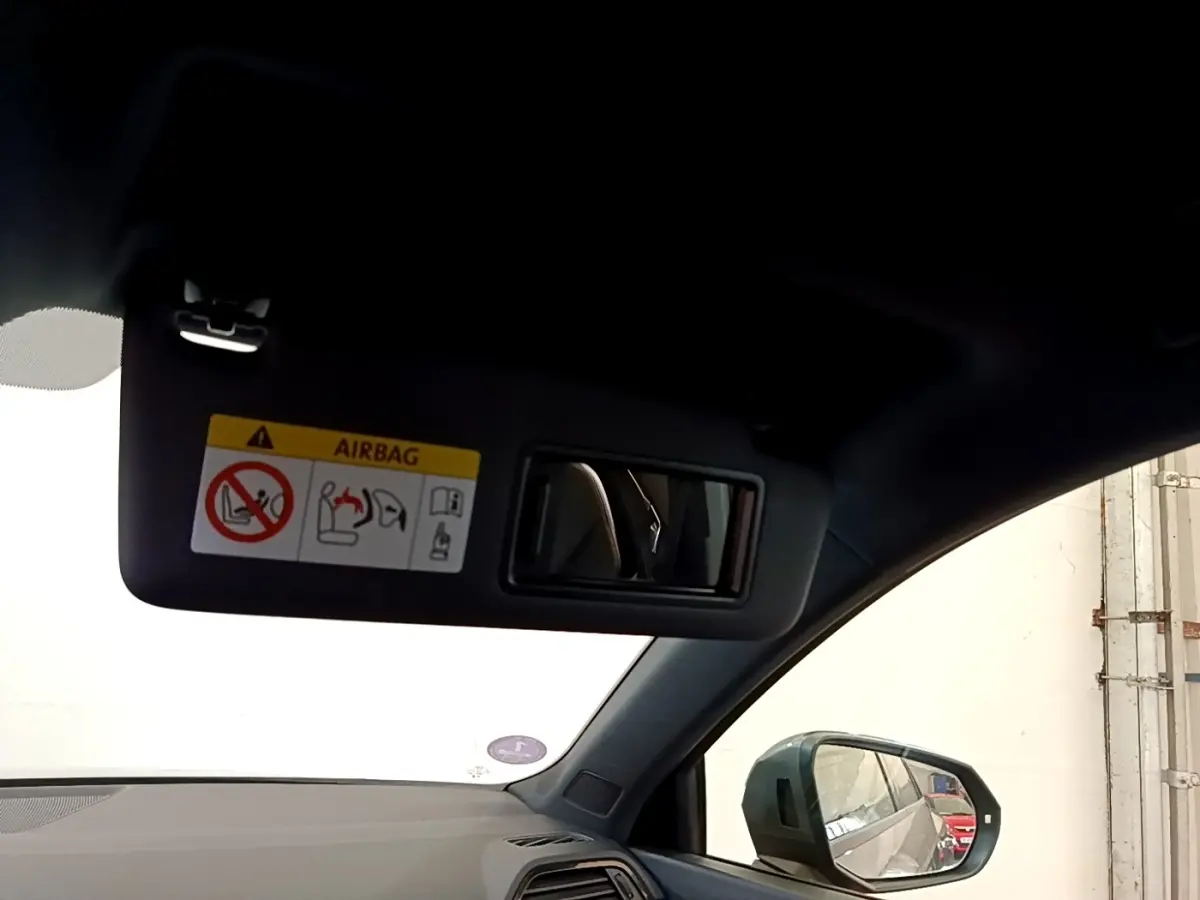 Intérieur Audi Q3 gris foncé 2021, vue côté gauche sur pare-soleil avec miroir et rétroviseur extérieur.