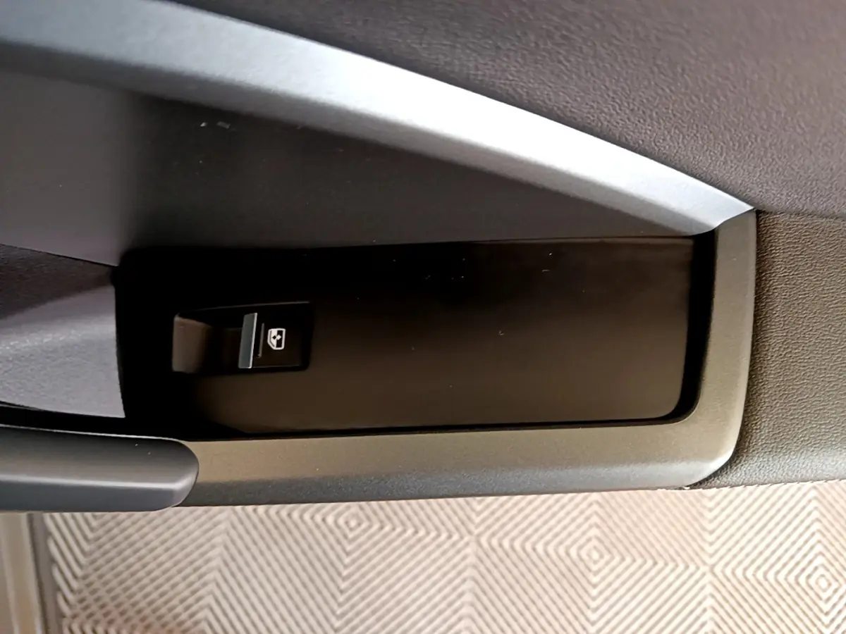Gros plan sur l'interrupteur de lève-vitre côté conducteur de l'Audi Q3 gris foncé, version 35 TFSI 2021.