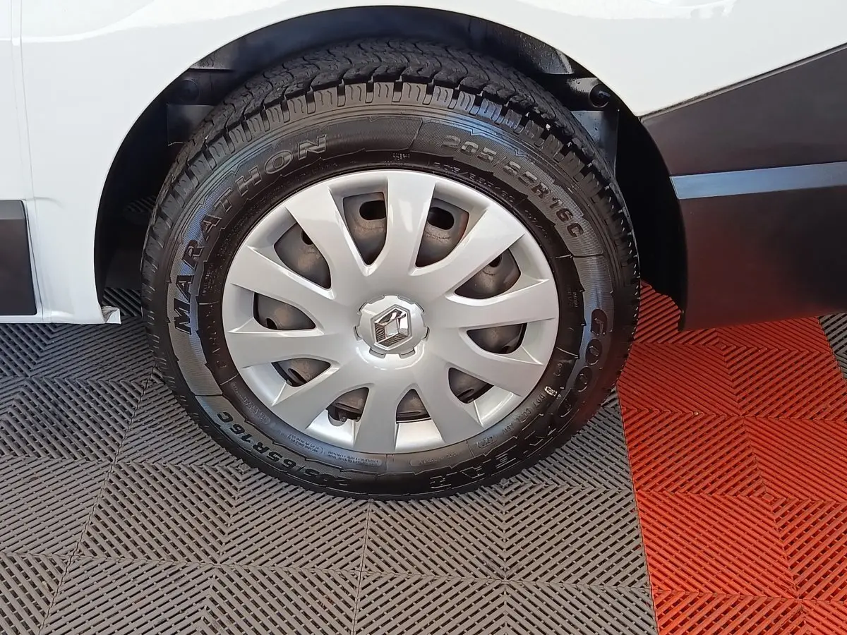 Gros plan sur la roue avant droite d’un Renault Trafic blanc, avec jante acier et enjoliveur gris.