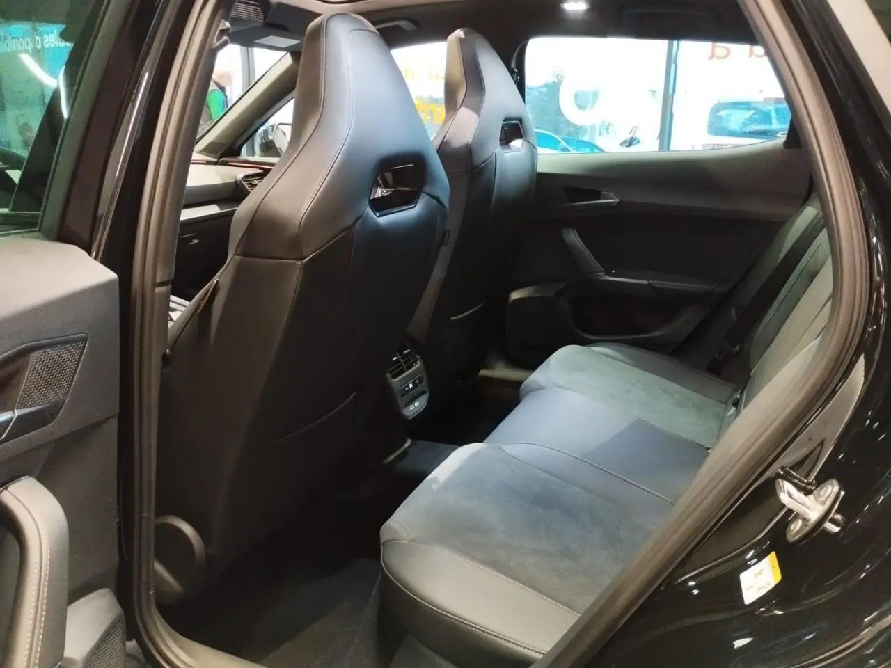 Vue côté droit arrière des sièges baquets noirs et suédine bleu astral du CUPRA Formentor 2026 avec porte ouverte.