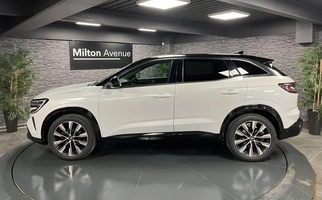 Profil droit du Renault Austral blanc Glacier avec toit noir étoilé et jantes alliage 19 pouces Komah diamantées noires.