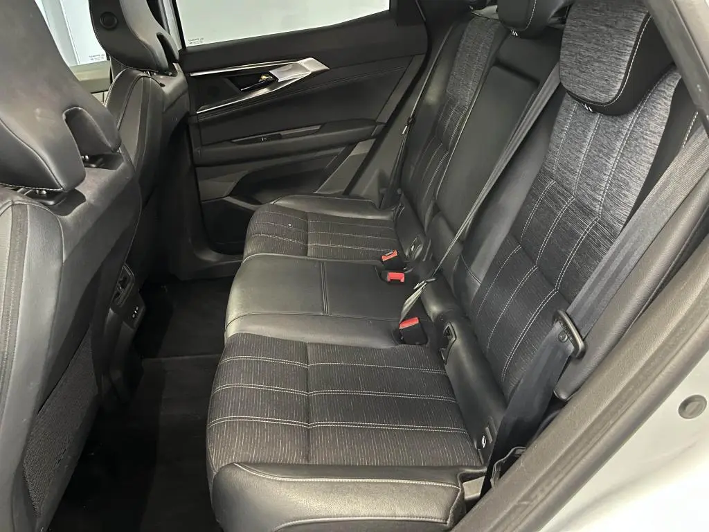 Vue côté droit de la banquette arrière en simili-cuir et tissu gris du Renault Austral blanc, avec ceintures et appuie-têtes visibles.