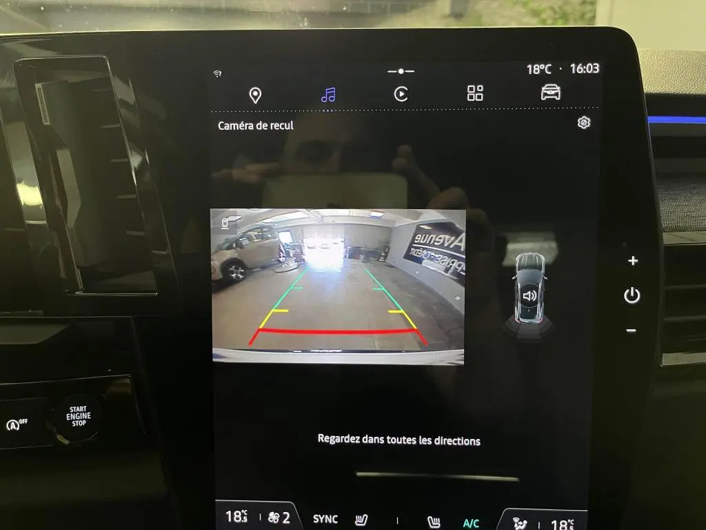 Écran central du Renault Austral 2023 montrant la caméra de recul avec guidage coloré et vue arrière intérieure.