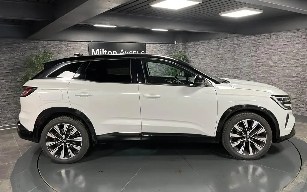 Profil droit du Renault Austral blanc Glacier avec toit noir étoilé et jantes alliage 19 pouces Komah diamantées.