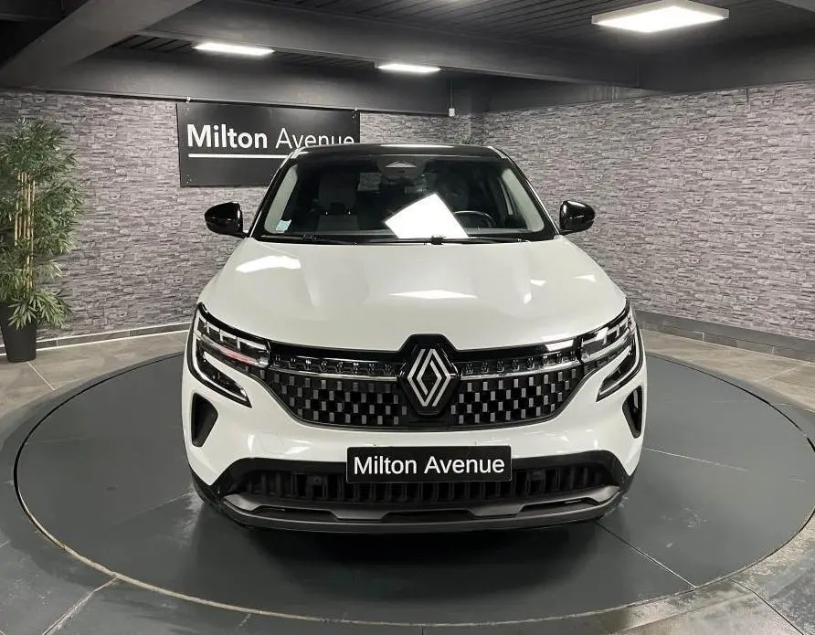 Renault Austral blanc vue de face en intérieur avec calandre damier chrome sombre et toit noir étoilé