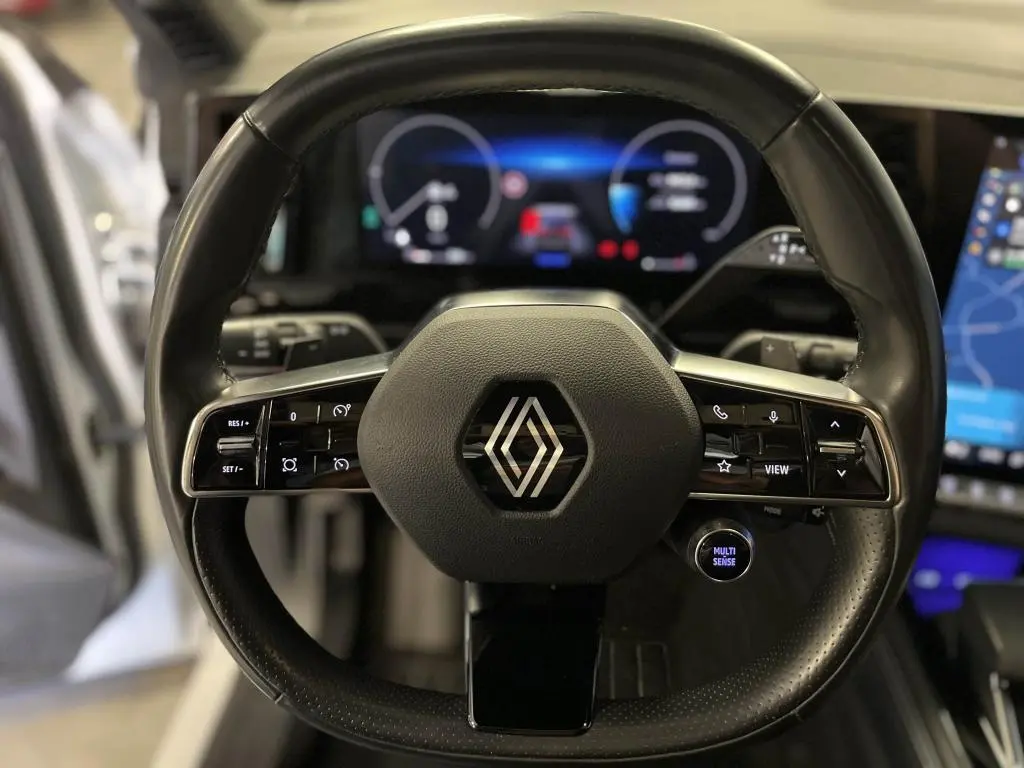 Volant cuir noir de Renault Austral 2023 avec commandes intégrées et tableau de bord numérique en arrière-plan.