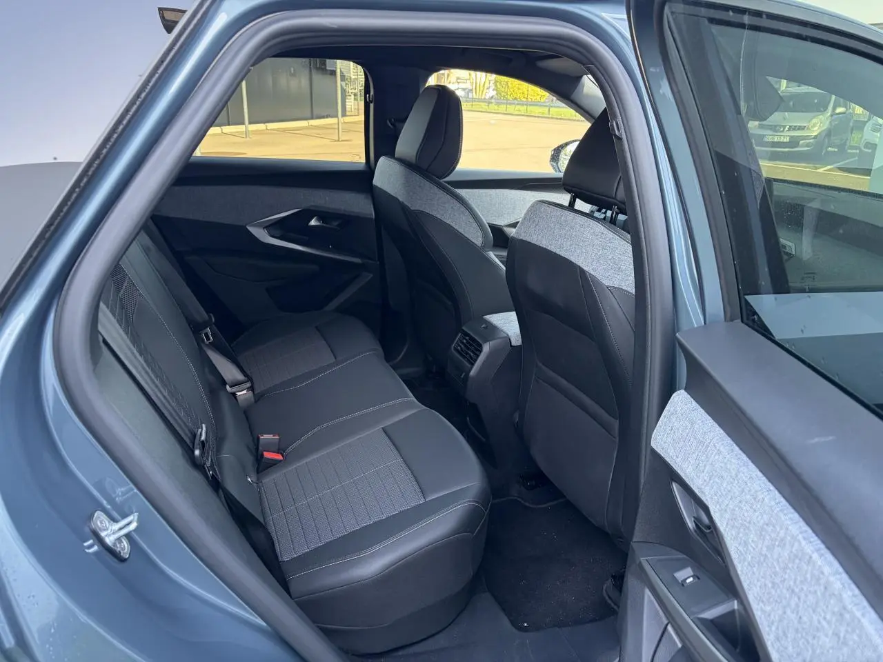 Vue intérieure côté gauche sur la banquette arrière et les sièges avant du Peugeot 3008 bleu Ingaro 2024.