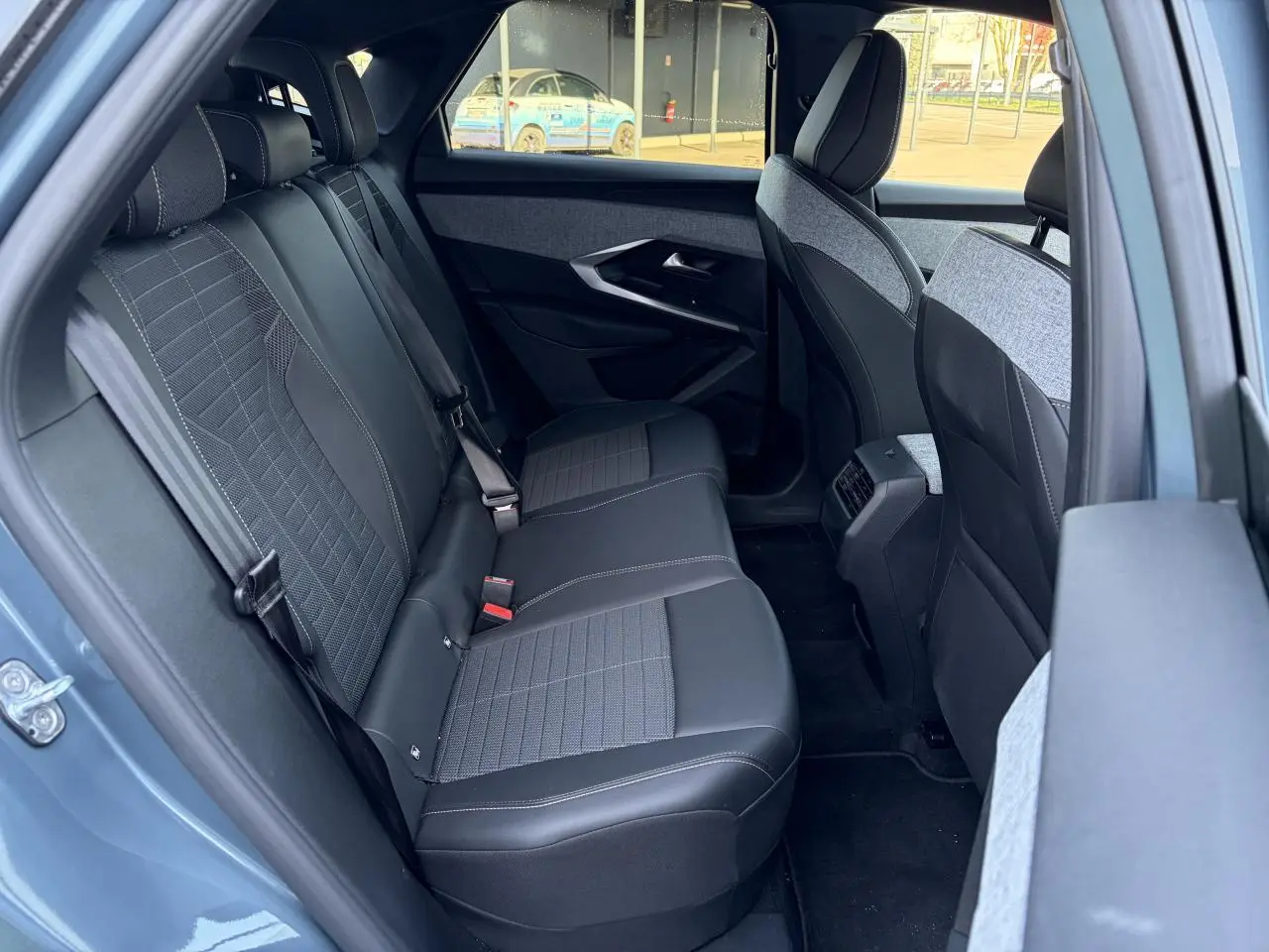Vue intérieure côté gauche sur la banquette arrière tissu et cuir du Peugeot 3008 bleu Ingaro 2024.