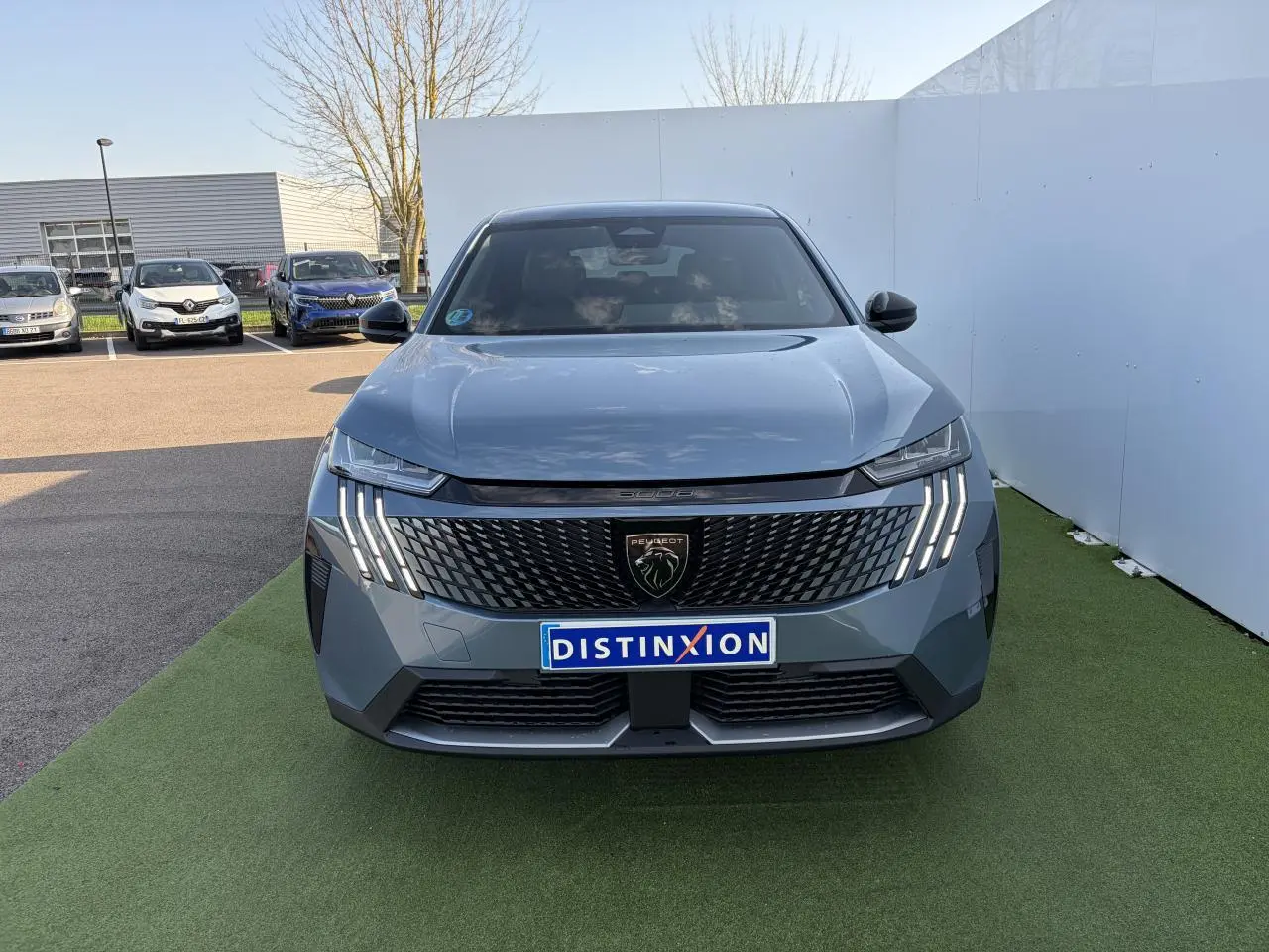 Vue frontale d'un Peugeot 3008 bleu Ingaro 2024 avec calandre noire et feux LED en griffes distinctifs.