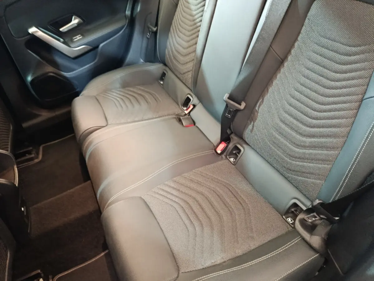 Vue intérieure côté arrière droit montrant la banquette 3 places en tissu et cuir du Mercedes GLA 250 e gris foncé.