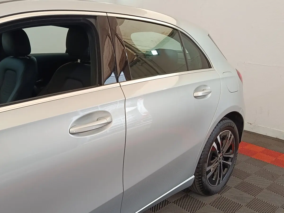 Vue latérale droite sur la porte arrière et jante noire d’un Mercedes GLA 250 e Business Line gris foncé.