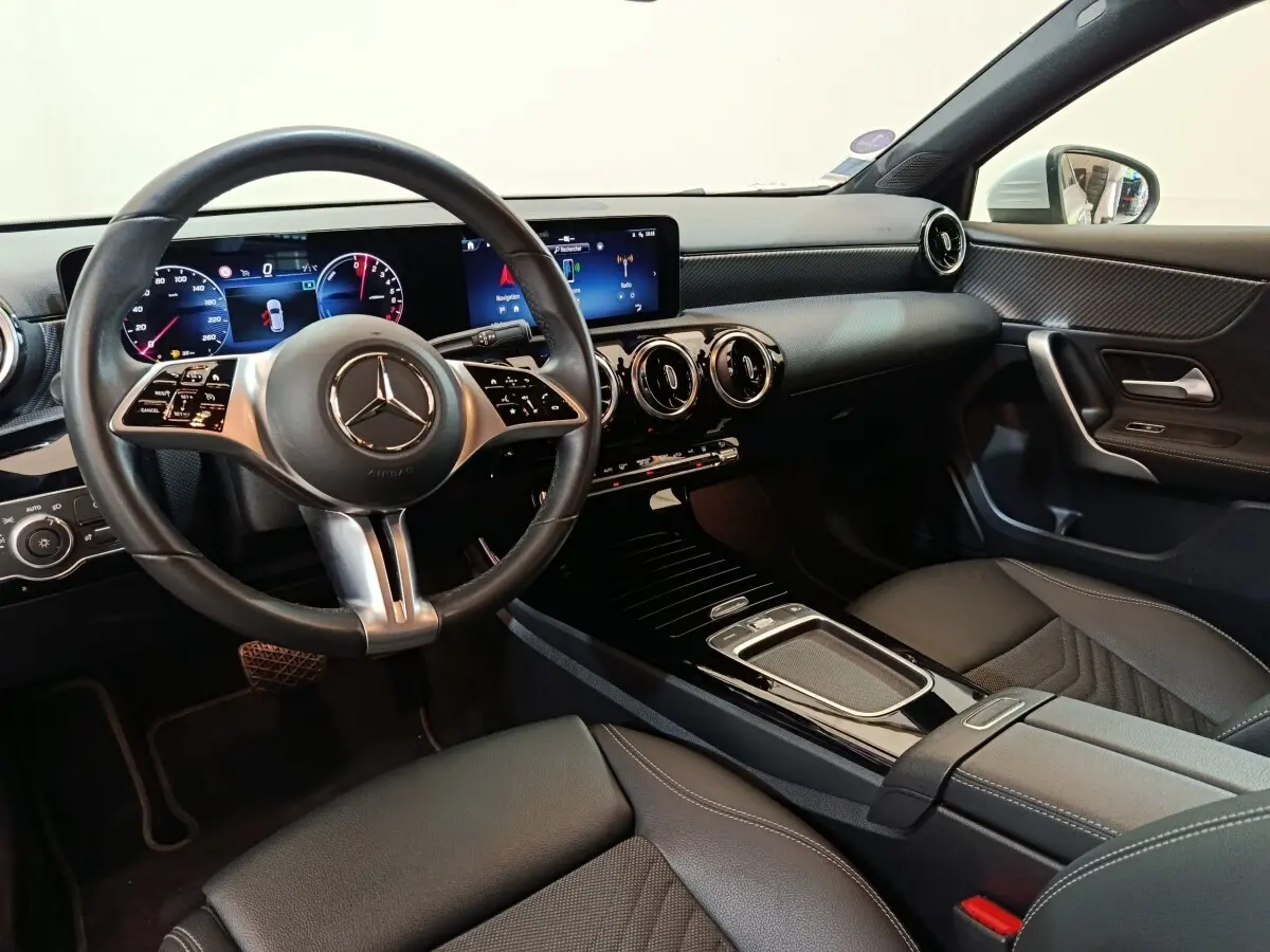 Vue intérieure côté conducteur du Mercedes GLA 250 e Business Line 2023, avec tableau de bord numérique et volant cuir noir.