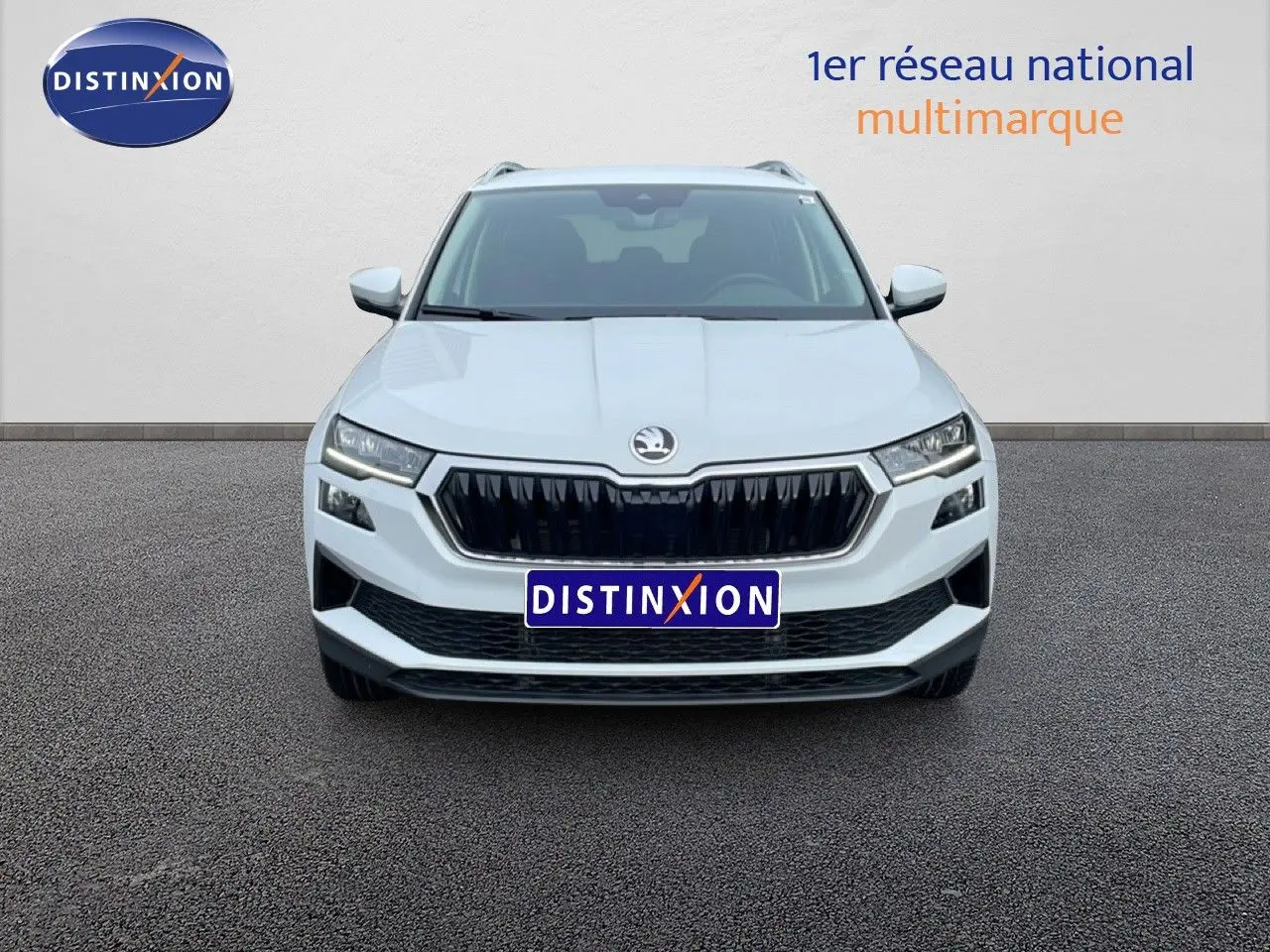 Vue de face d’un Skoda Karoq blanc glacier 2025 avec calandre noire et phares LED distinctifs.