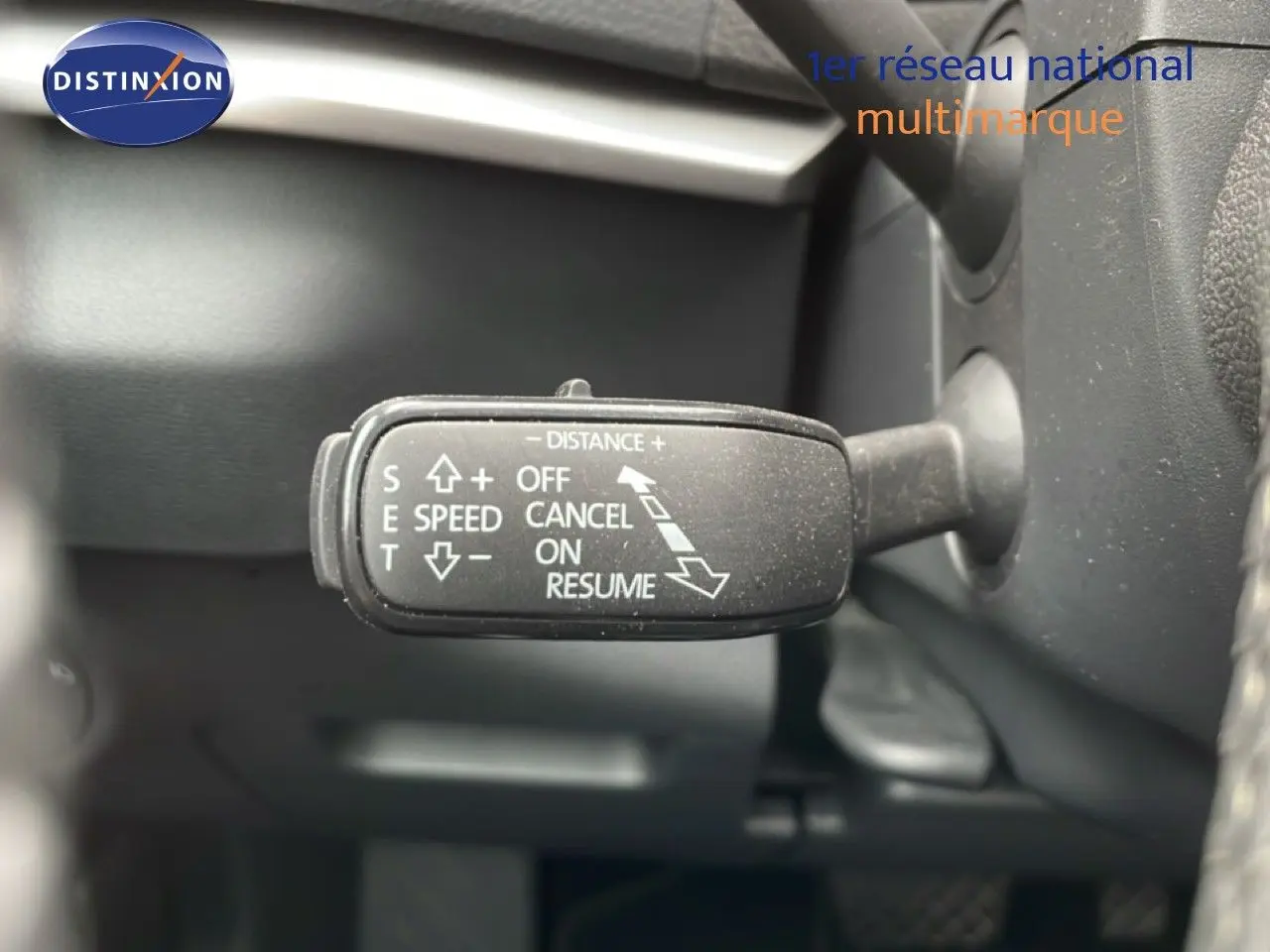 Gros plan sur la commande de régulateur de vitesse du Skoda Karoq blanc glacier, intérieur noir.
