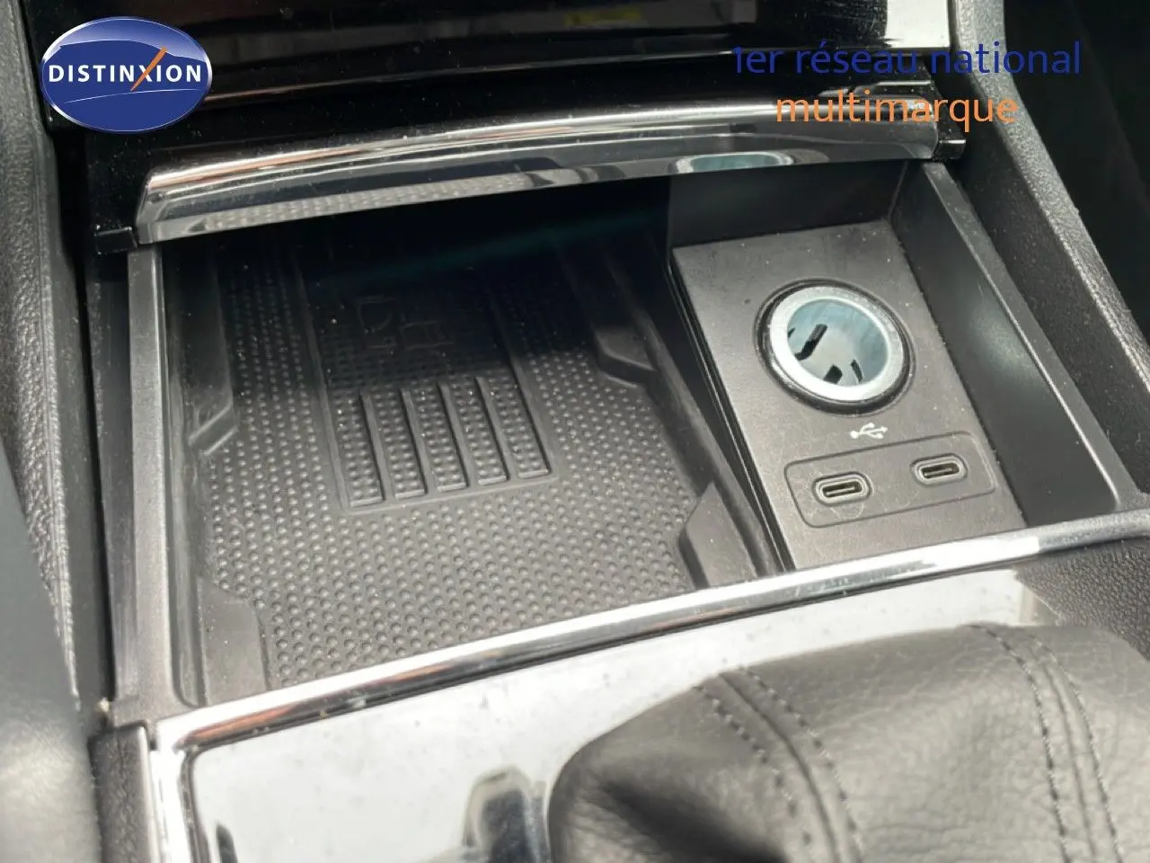 Gros plan sur la console centrale du Skoda Karoq blanc glacier, montrant prise 12V et ports USB-C.