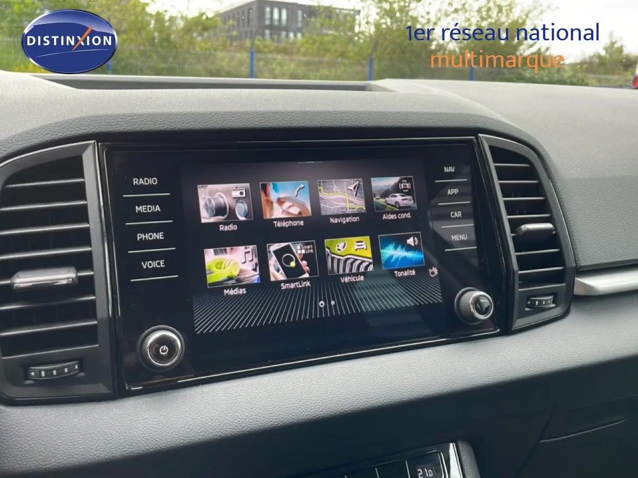 Vue rapprochée de l'écran tactile central du Skoda Karoq blanc glacier, affichant les options multimédias et de navigation.