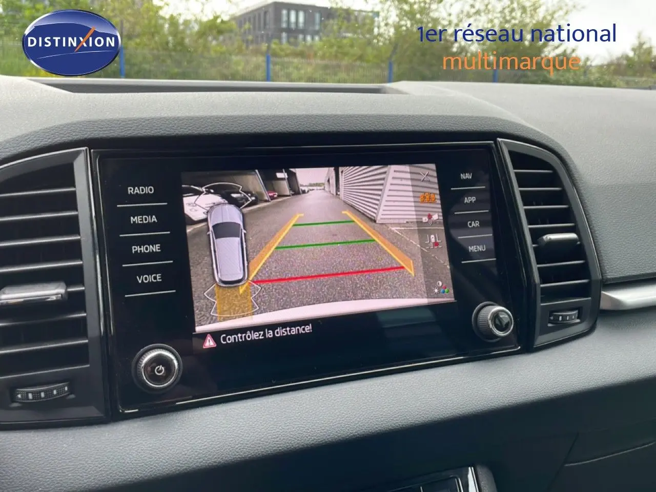 Écran central du Skoda Karoq montrant la caméra de recul avec guidage de trajectoire en couleurs.