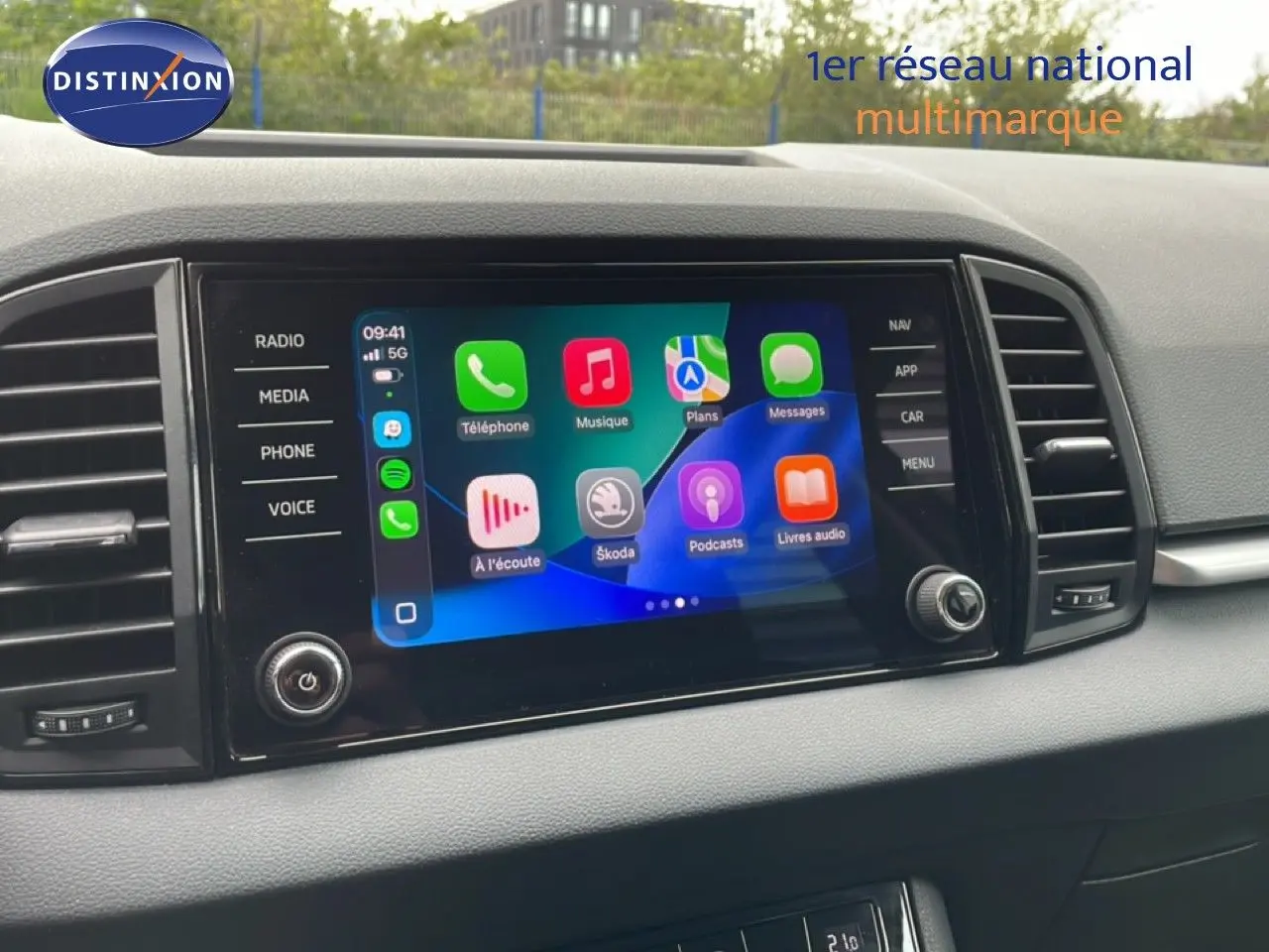 Écran tactile central du tableau de bord du Skoda Karoq blanc glacier, affichant les applications connectées.