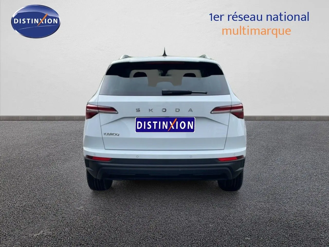 Vue arrière d'un Skoda Karoq blanc glacier 2025, avec feux arrière LED et logo SKODA visible.