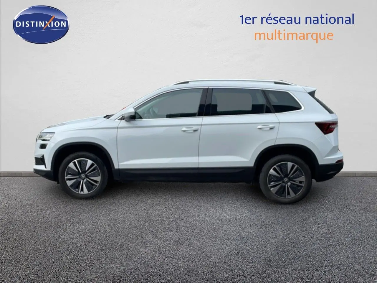Profil droit du SUV SKODA KAROQ blanc glacier 2025 avec jantes alliage bicolores et vitres teintées.