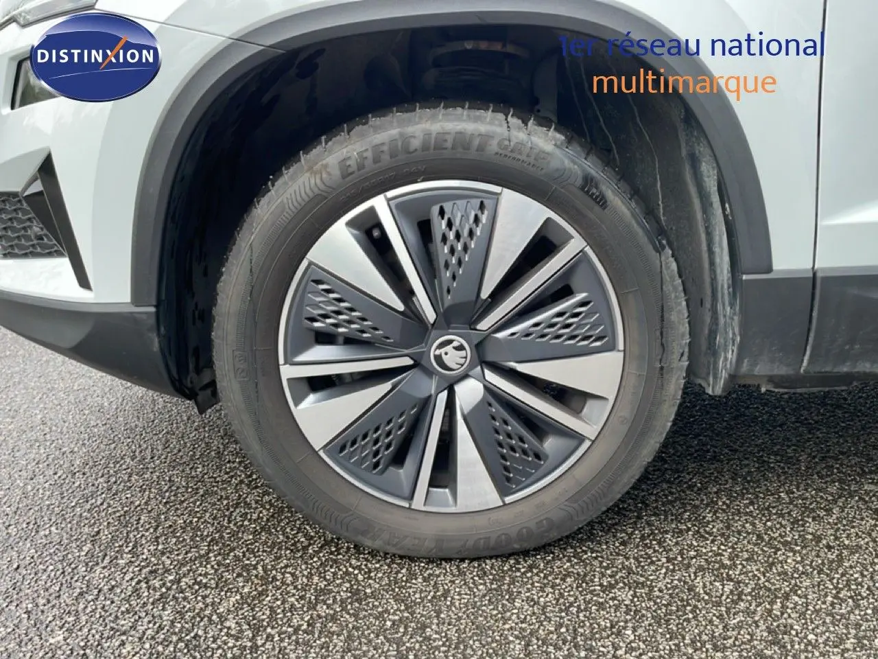 Gros plan sur la roue avant droite du Skoda Karoq blanc glacier, mettant en valeur la jante alu biton au design moderne.
