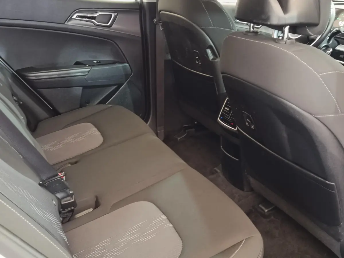 Vue intérieure arrière du Kia Sportage 2022 montrant la banquette noire et les dossiers des sièges avant.