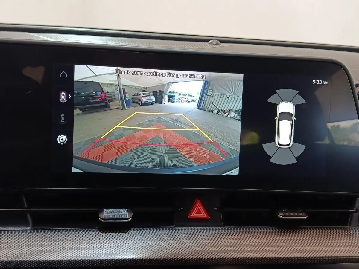 Écran tactile du tableau de bord montrant la caméra de recul et l’aide au stationnement du Kia Sportage blanc.