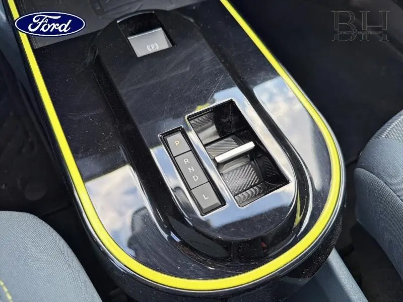 Gros plan sur la console centrale noire avec contour jaune Limone et levier de boîte automatique de la Fiat Grande Panda.