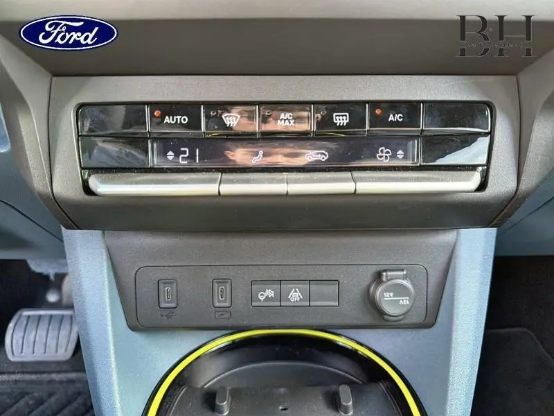 Gros plan sur la console centrale avec commandes climatisation et prises USB d’une Fiat Grande Panda noire.