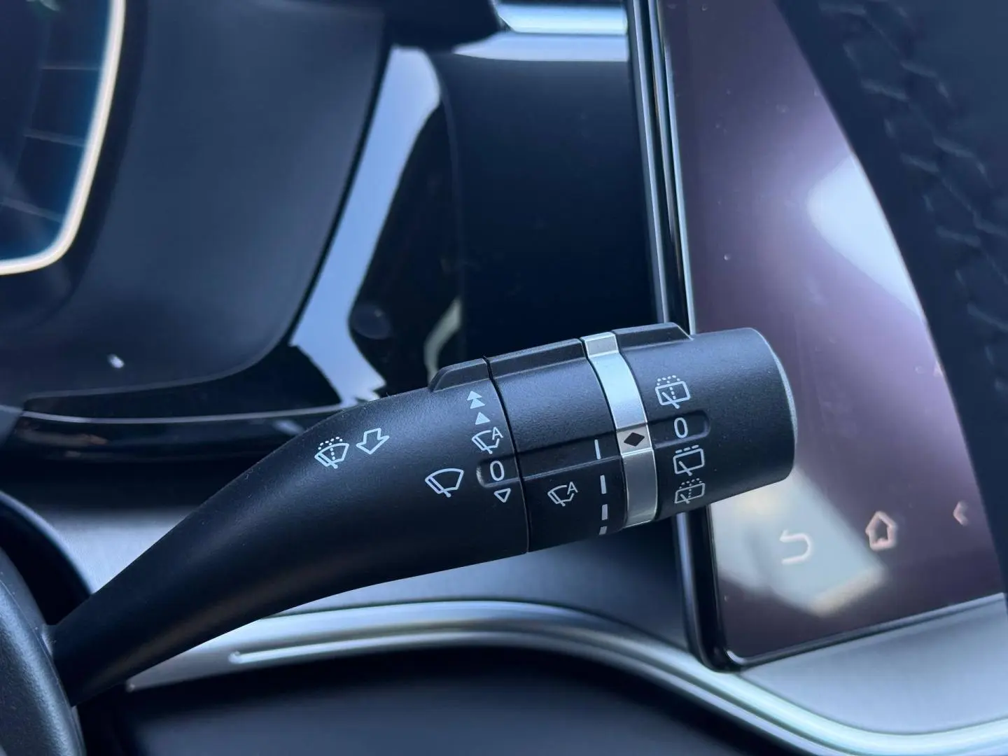 Gros plan sur la manette d’essuie-glace côté gauche du tableau de bord du BYD SEAL U 2026, intérieur noir et écran tactile.