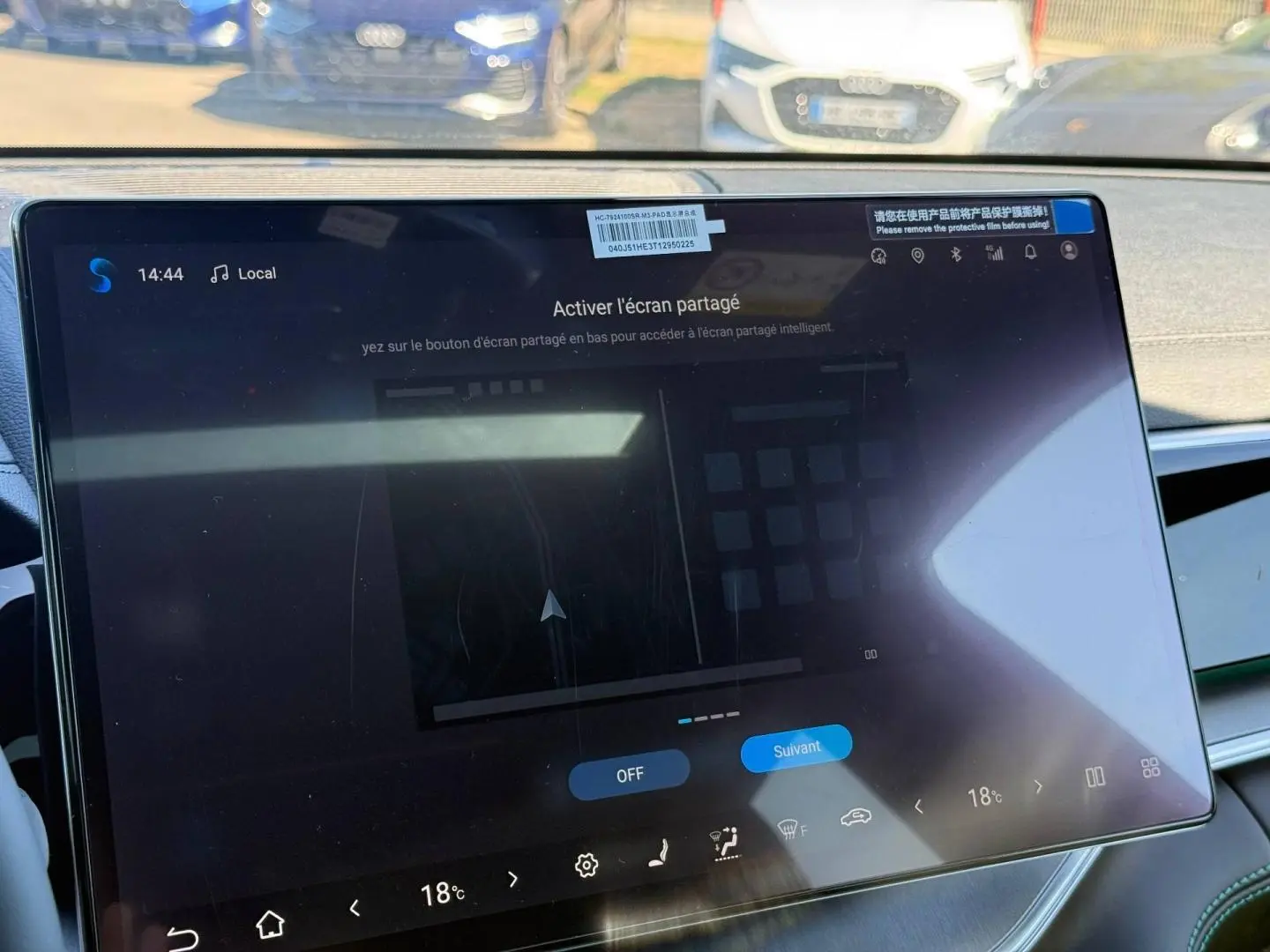 Gros plan sur l'écran tactile central du tableau de bord du BYD SEAL U 1.5 DM-i en intérieur, avec reflet extérieur.