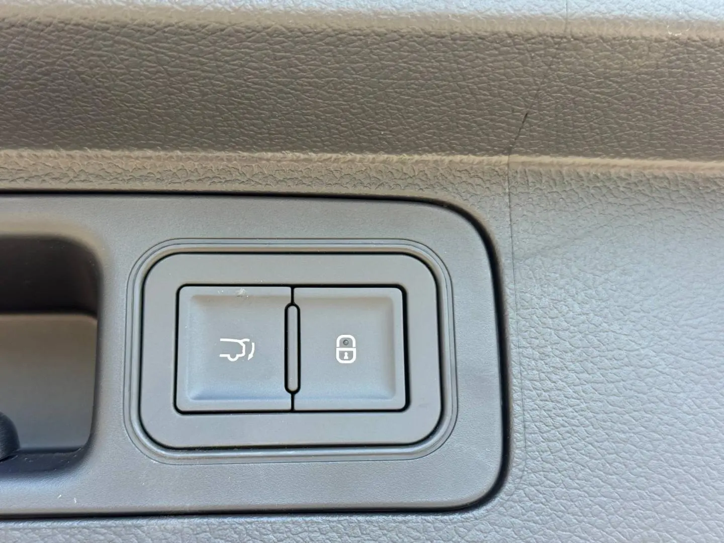 Détail des boutons d'ouverture de coffre et de verrouillage sur la porte intérieure d'un BYD SEAL U Boundless Cloud métallisé.