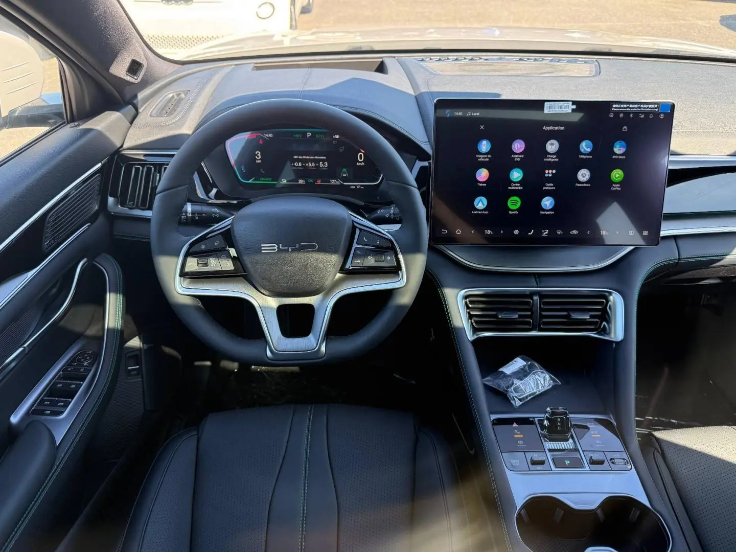 Vue intérieure frontale du tableau de bord du BYD SEAL U avec volant multifonction et grand écran tactile central.