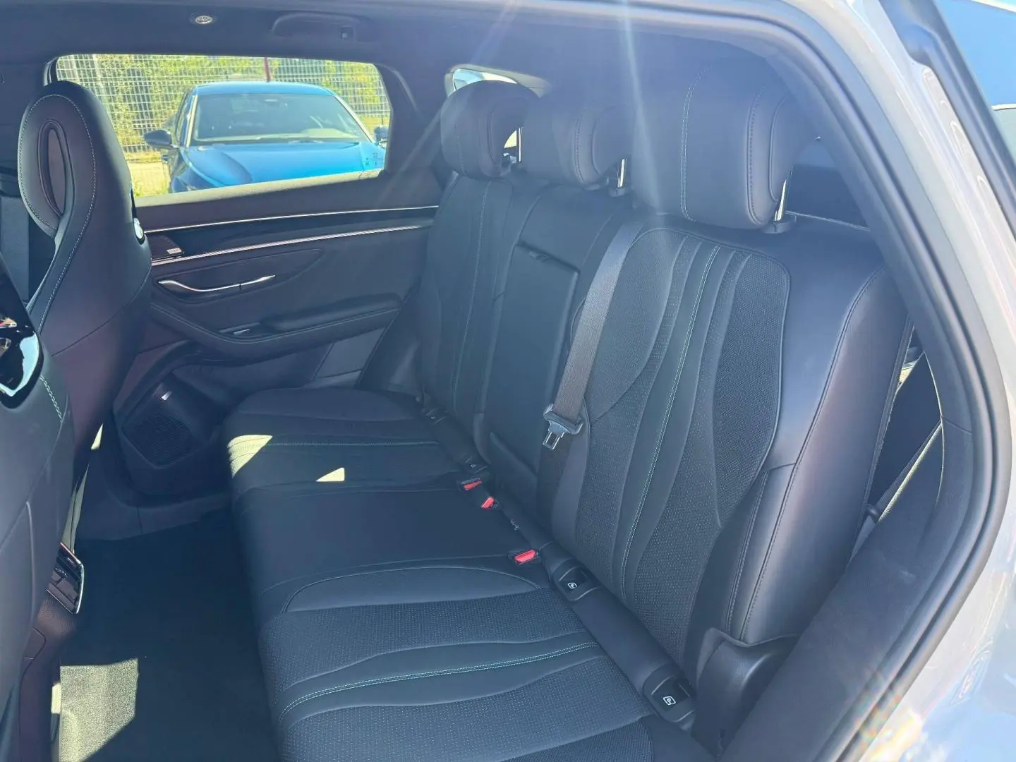 Vue intérieure côté droit montrant la banquette arrière en cuir noir avec surpiqûres vertes du BYD SEAL U 2026.