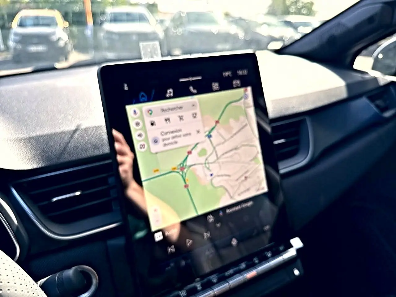 Vue intérieure du tableau de bord du Renault Symbioz gris rafale, écran tactile affichant un GPS cartographique.
