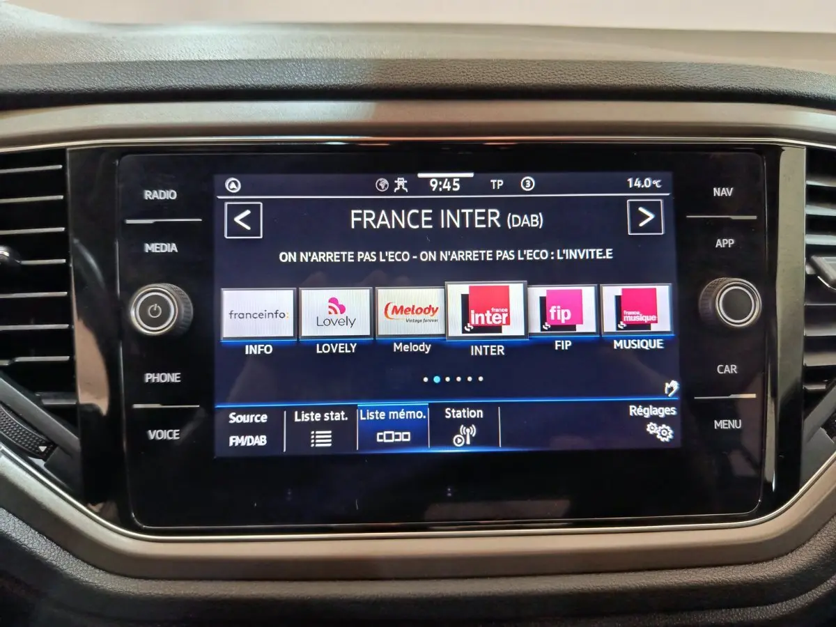 Écran tactile central affichant les stations radio dans l'habitacle du Volkswagen T-Roc gris foncé, vue rapprochée.